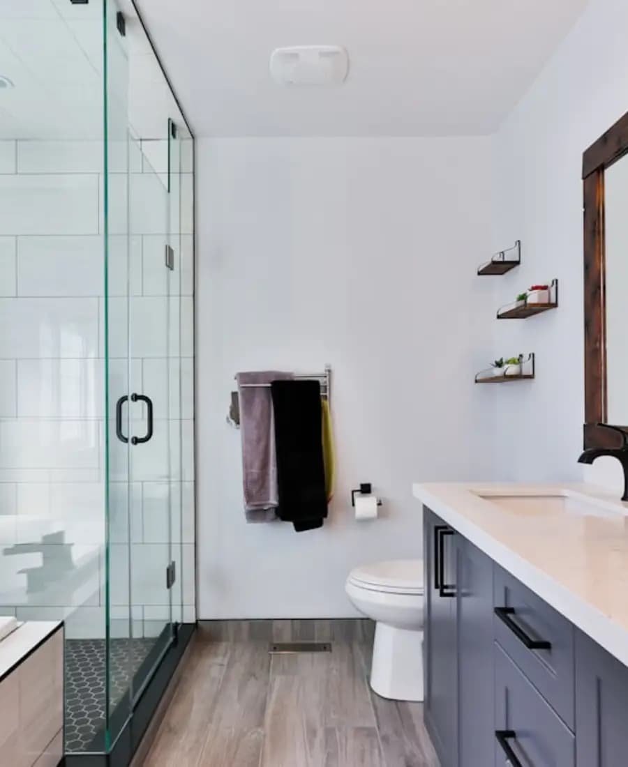 A finished bathroom with a walk-in shower and a double vanity