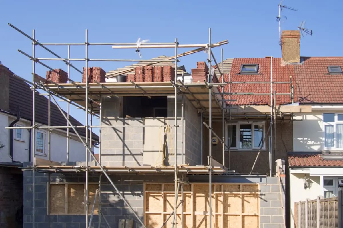 A terrace of houses with scaffolding to the roof for a loft conversion